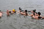 Zdjęcie przedstawia grupę ludzi w wodzie w czapkach i rękawiczkach, zimową porą, fot. J. Koniecko