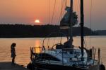 The photo shows a girl on the pier and a moored sailing yacht on Lake Necko during sunset, photo J. Koniecko