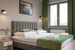 Pokój szaro-zielony z dużym łóżkiem